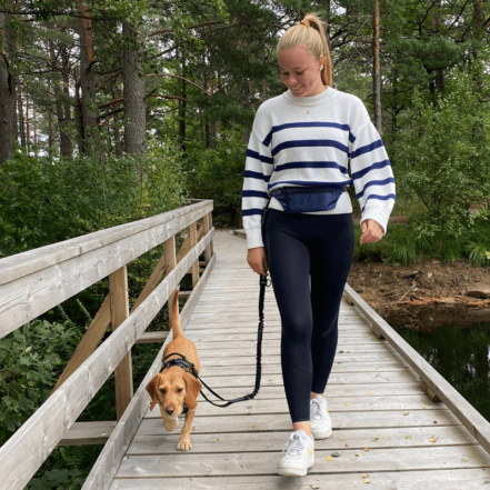 jente som smiler går tur med sin hund og løpebelte til hund fra hobbyhund