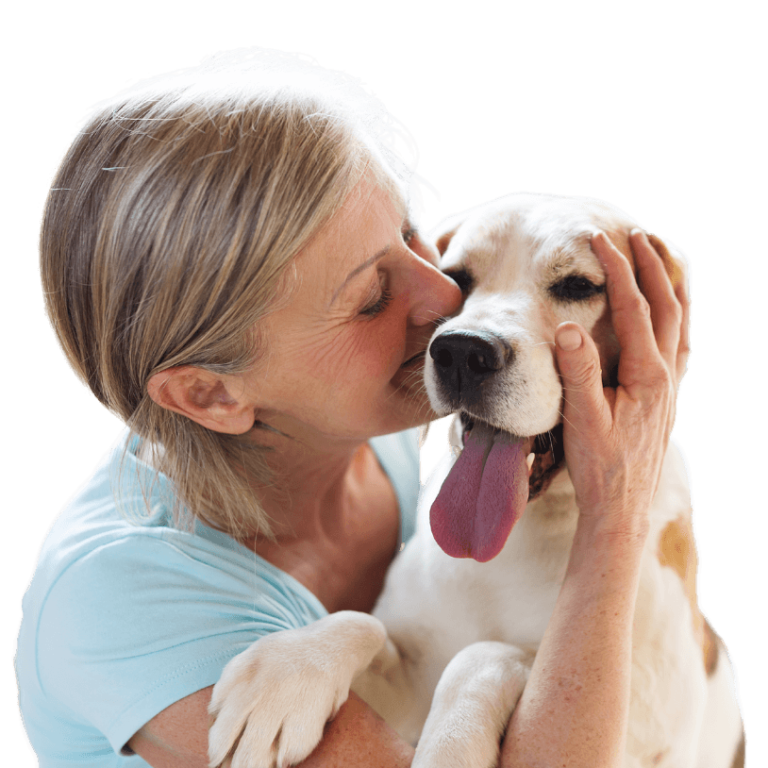 voksen dame kysser blid hund med tungen ut på kinnet mens hund holder hånden på hodet til hunden